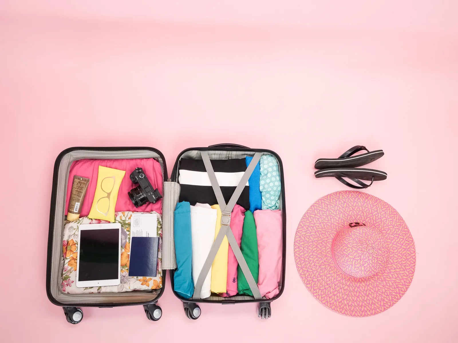 Open suitcase packed with clothing and travel essentials